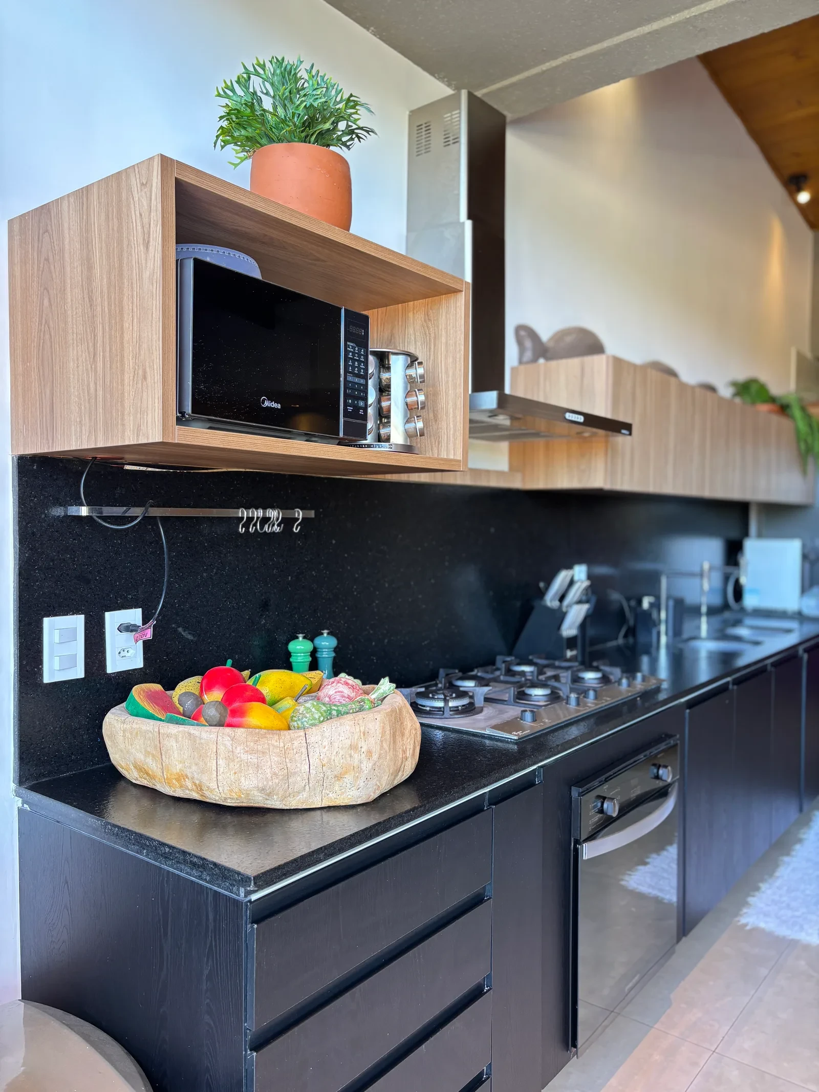 Cozinha com fogão a gás, forno e micro-ondas embutido.